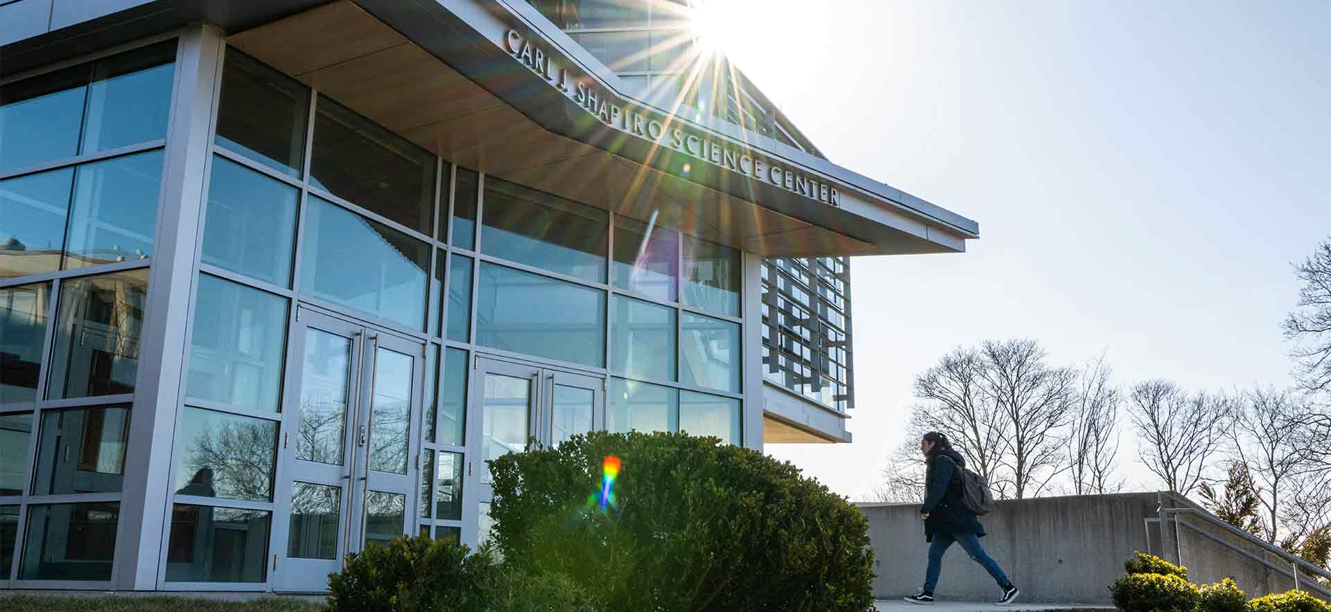 Shapiro Science Center building, a student walks toward the entrance