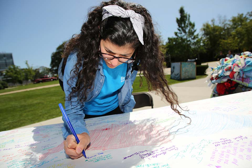 Person signs a banner for Hurricane Harvey victims