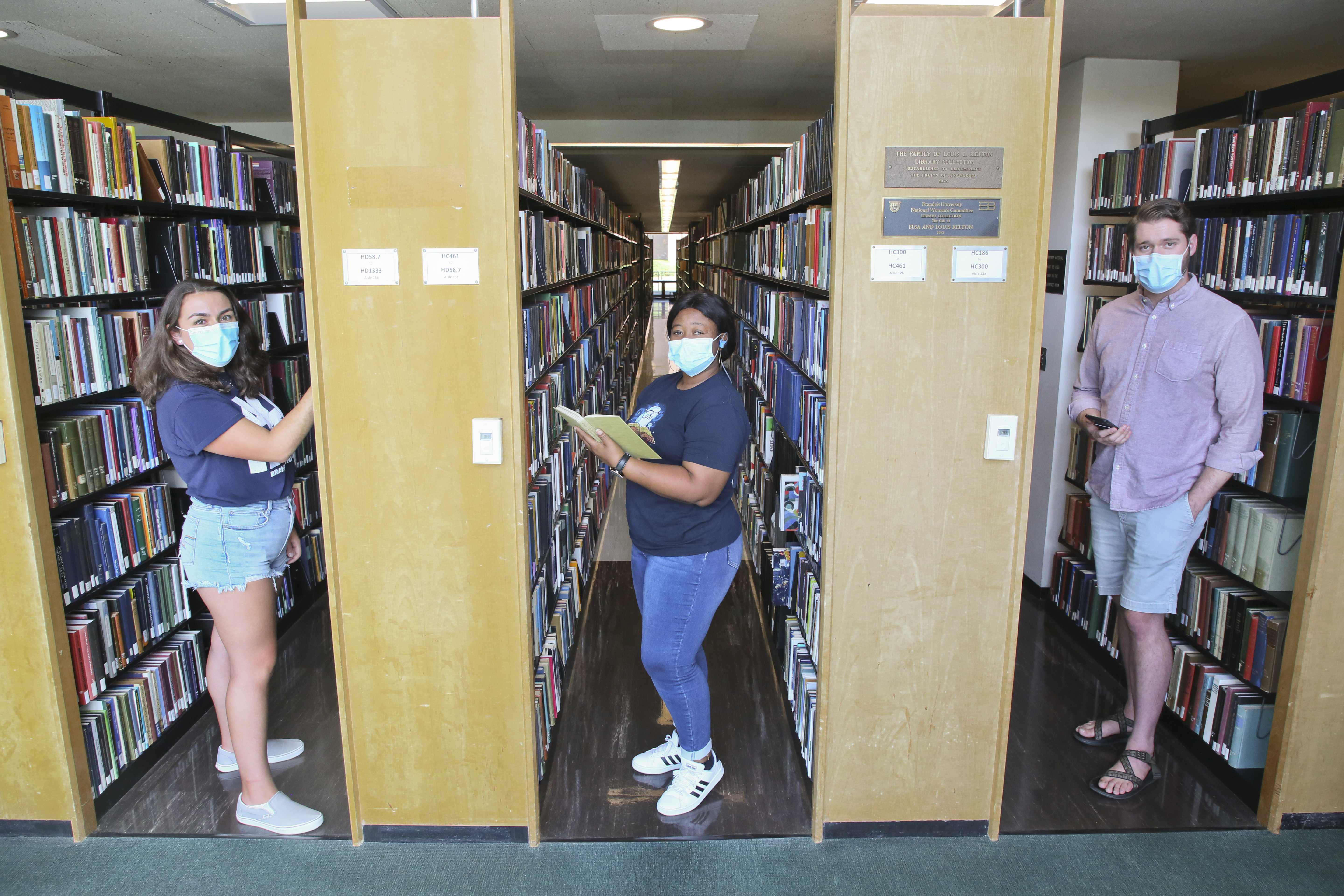 students between stacks in the library