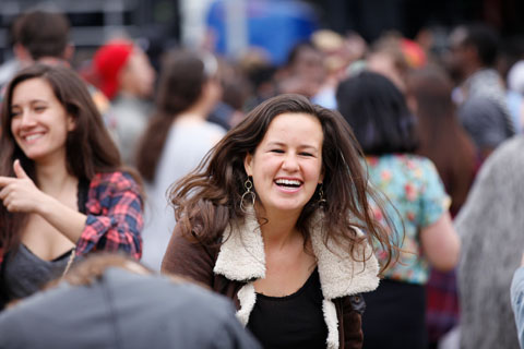 A laughing woman in the festival crowd.