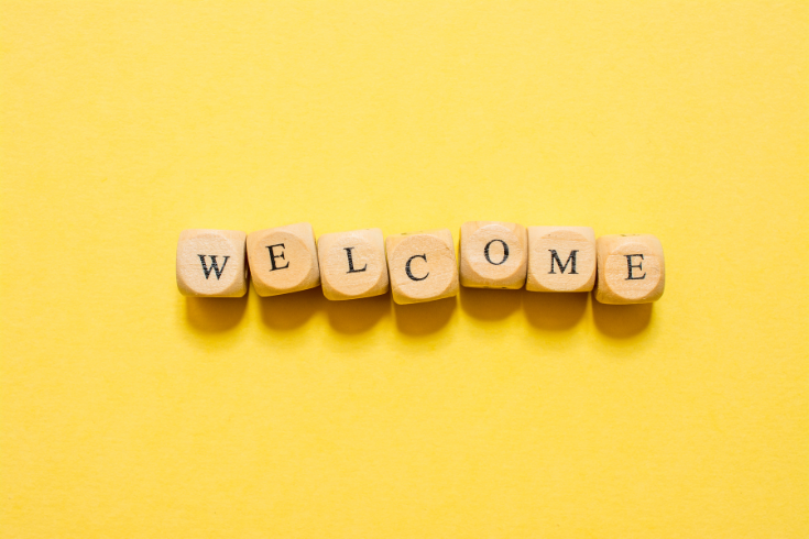 Yellow background with wooden cubes that read "Welcome"