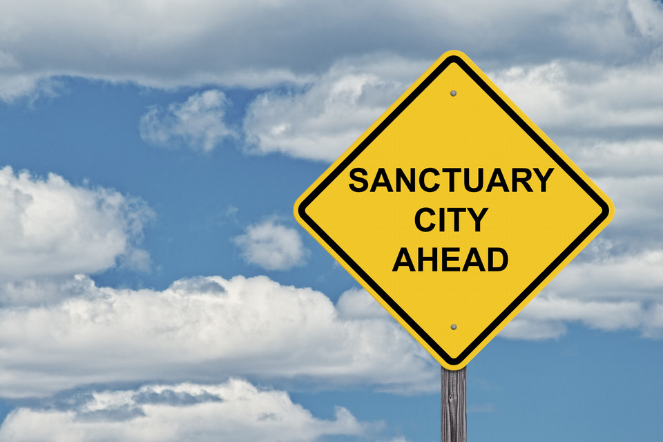 Yellow traffic sign with the text 'sanctuary city ahead'