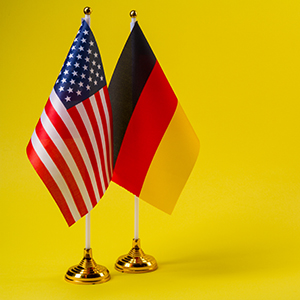 US and German flag on a yellow background
