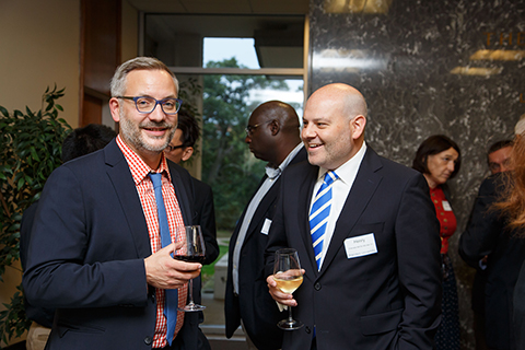 Panelists Nils Ringe ’01 and Henry J. Charrabé MA ’99, IBS MA’01 engaged in a conversation at the welcome reception.