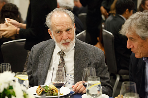 Physics Professor James Bensinger speaking with a guest at the festive gala dinner