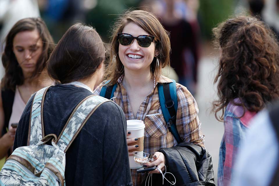 female students talking and walking around campus