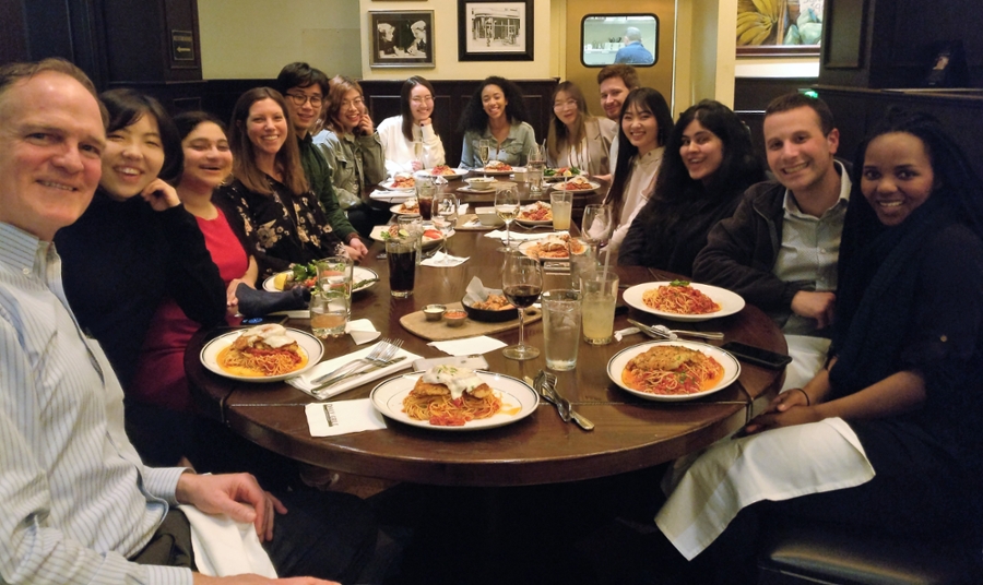 Students and staff around a dinner table.