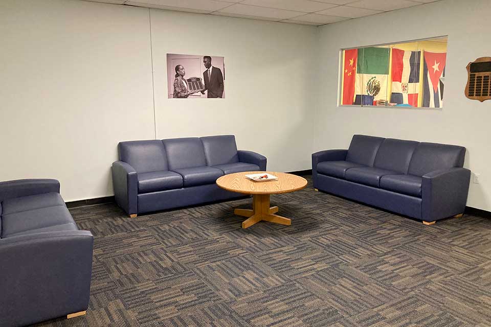 ICC Push Lounge, small space with 3 blue couches against the wall and a coffee table in the center