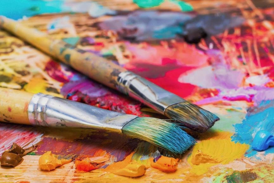 Artist's palette with paint-streaked brushes