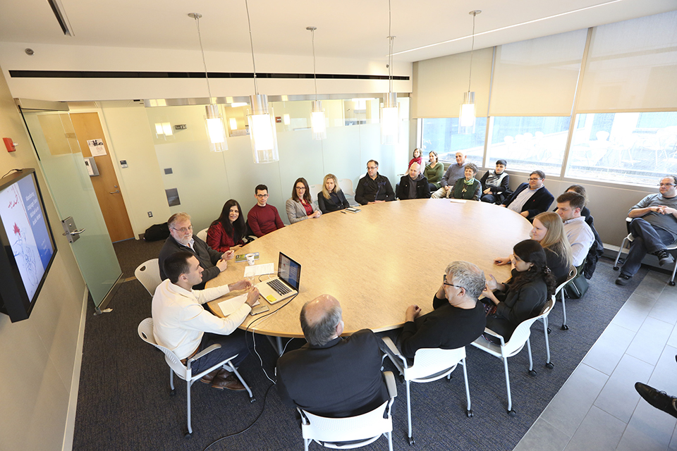 People gathered around an oval conference table, indoors