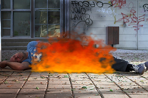 Man on fire lying on the ground