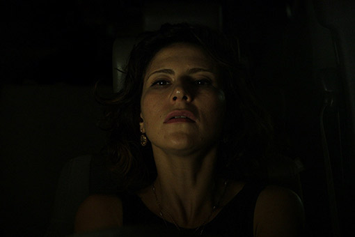Woman's face emerging from darkness