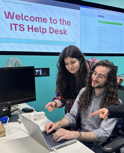 Two people sitting at the ITS help desk with a computer