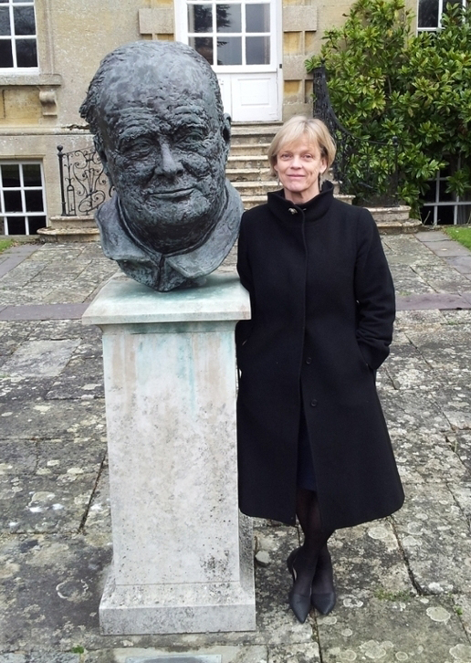 Jytte Klausen stands next to a statue of a head