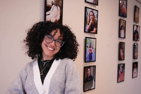 Shelley Polanco in front of her photo exhibit in the library