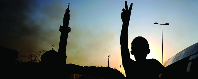 A youth flashes a celebratory victory sign after rebel forces overrun Muammar Qaddafi’s fortified headquarters in Libya’s capital, Tripoli.