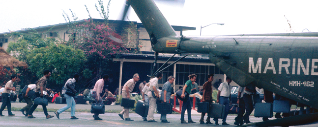 THE LUCKY ONES: Under the watchful eye of U.S. Marines, a  line of nonmilitary evacuees, luggage in hand, board an aircraft at Tan Son Nhut Air Base, near Saigon.