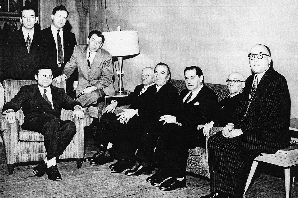 A black and white photo of a group of faculty members in suits