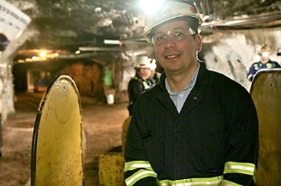 assistant professor of physics Bjoern Penning, wearing a hard hat and headlamp inside a former mine that is now the Sanford Underground Research Facility