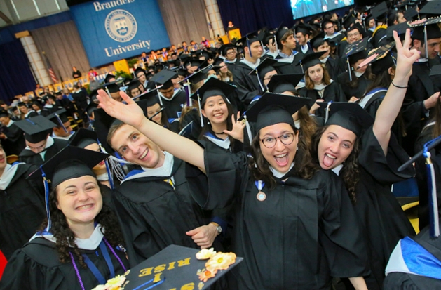 A crowd of students celebrates graduation at Brandeis