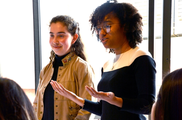 Madeline Bisgyer ’20 and Noaem Shurin ’19, speak to a group in front of a window 