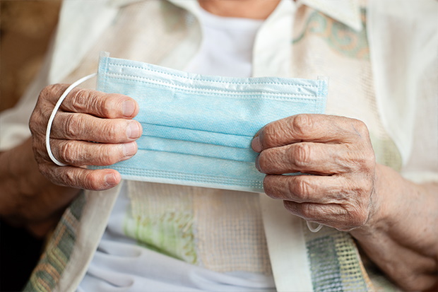 Woman holding face mask for virus