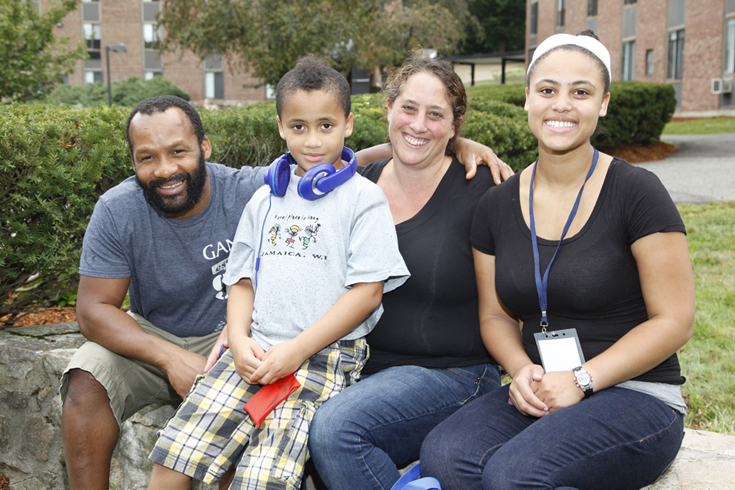 Two parents sitting with school-aged son and college-aged daughter