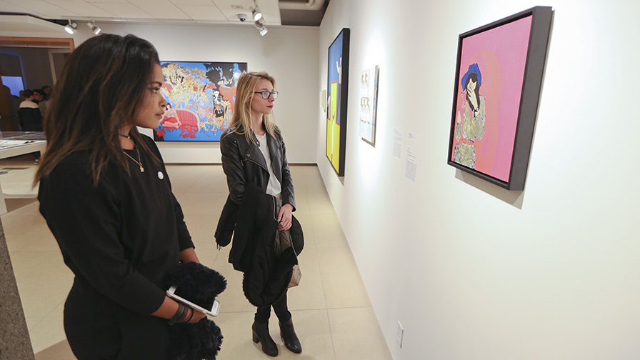 Two women looking at a painting