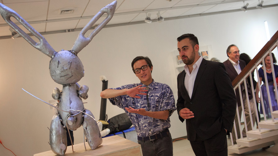 a student guide explains a sculpture to a museum visitor