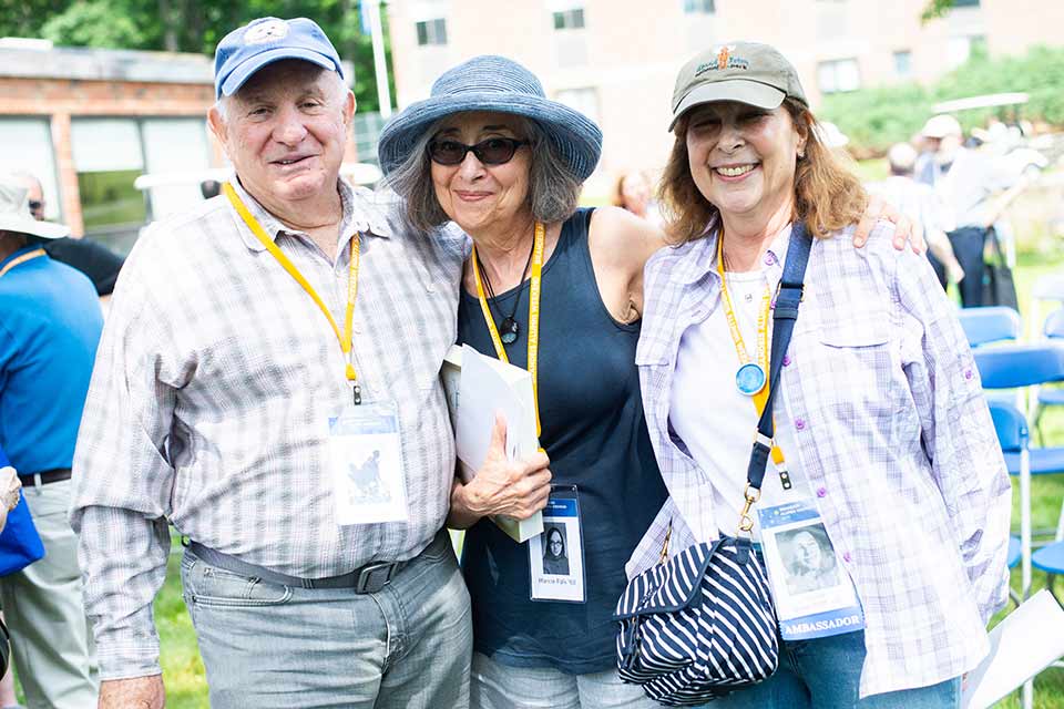 Three people smiling on the Brandeis campus