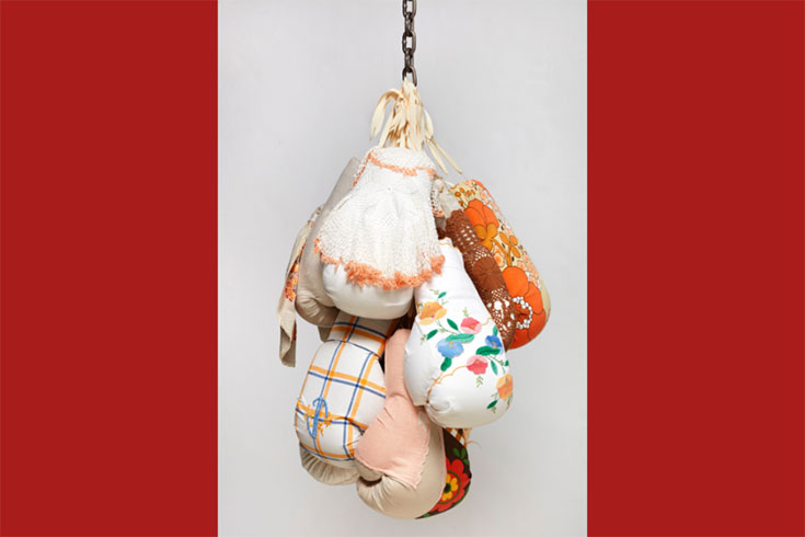 Art installation of boxing gloves hanging from a chain and ribbon