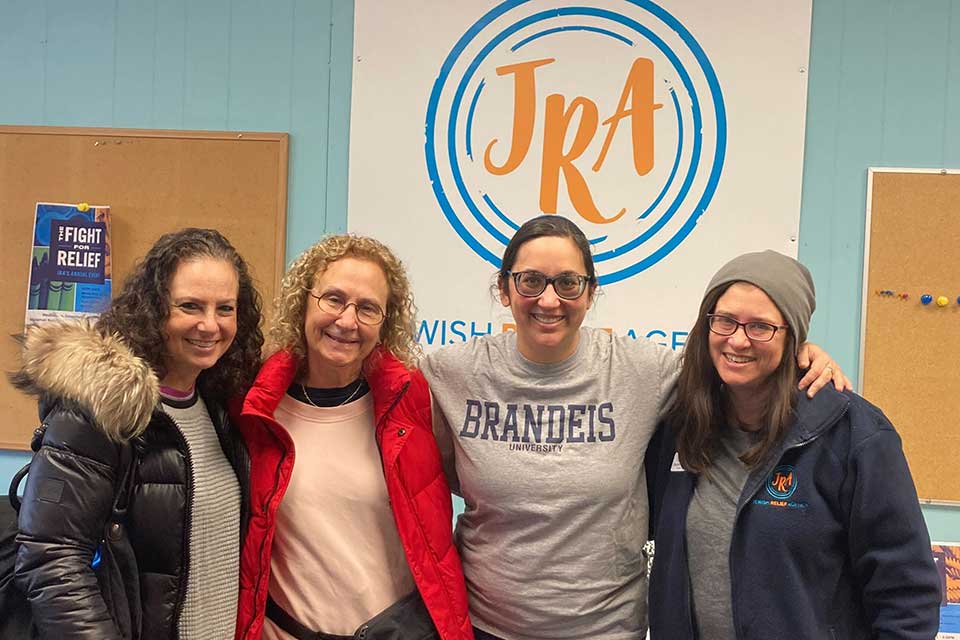 People pose in front of a banner that says JRA