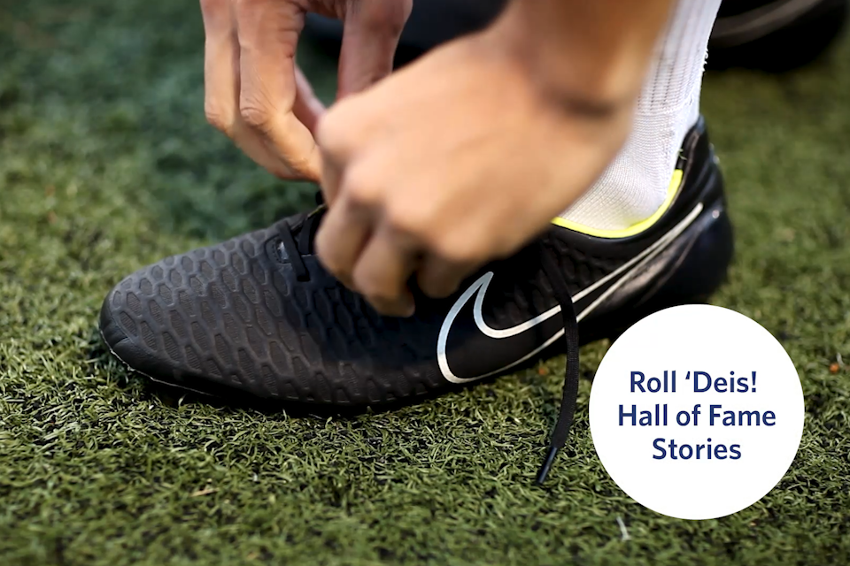 Hand lancing up a cleat with blue text in a white bubble that says "Roll 'DEIS: Hall of Fame Stories" 