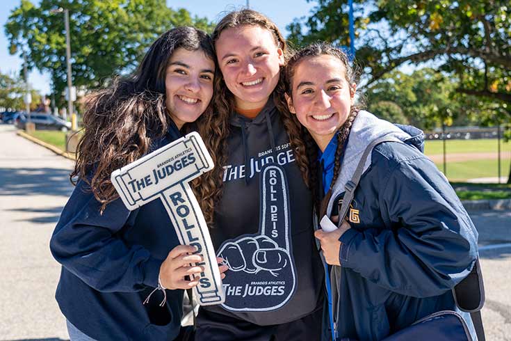 Three people smiling at homecoming