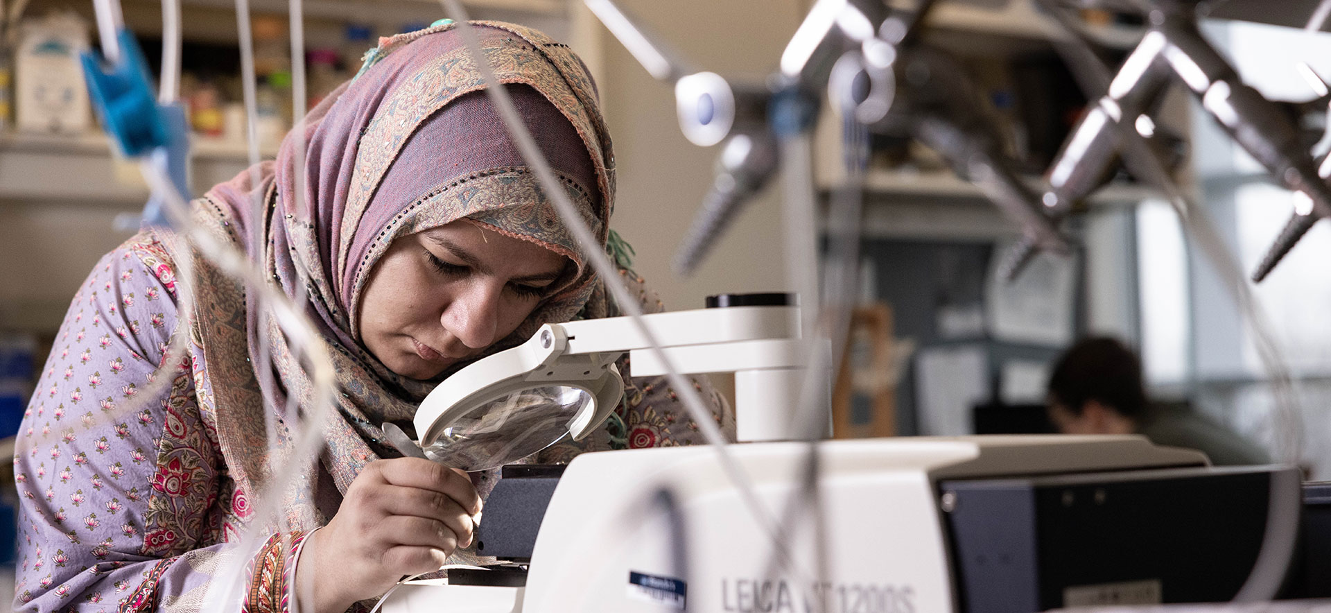 Graduate student researcher uses equipment in a lab