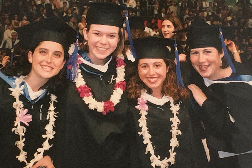 Group of femaie graduates wearing Hawaiian leis at graduation. 