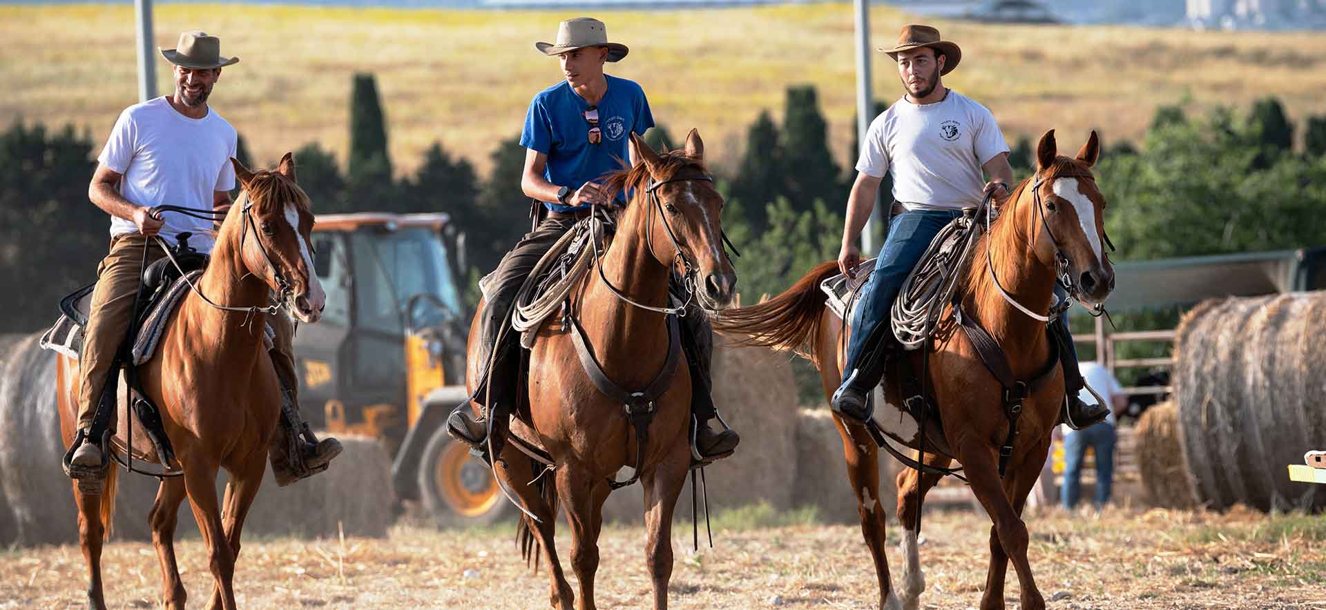 Members of the community on horseback herd cattle in the pasture.