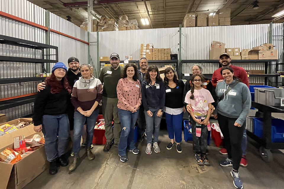 Group of people posing and smiling in a warehouse