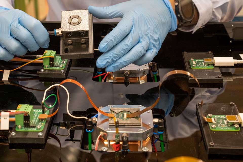 Close up of gloved hands working with wires