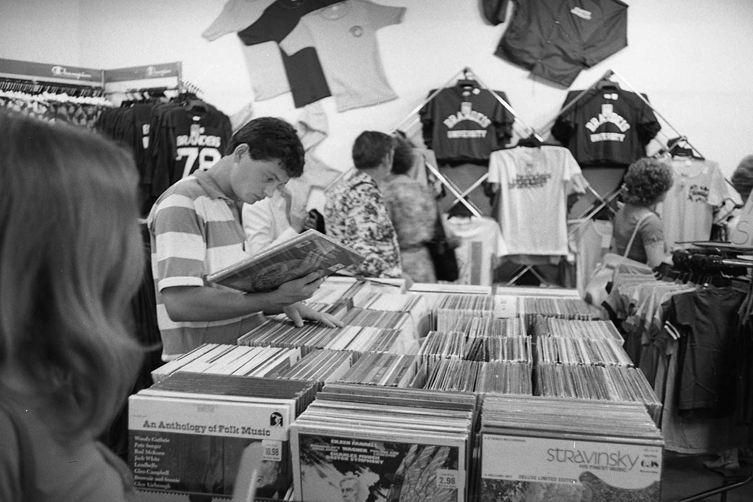 A student browses a shelf full of records.