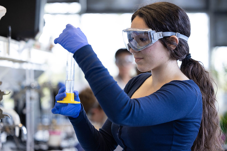 Student with safety goggles on working in a lab