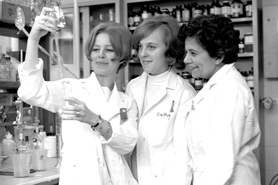 Archival photo of three people in a lab