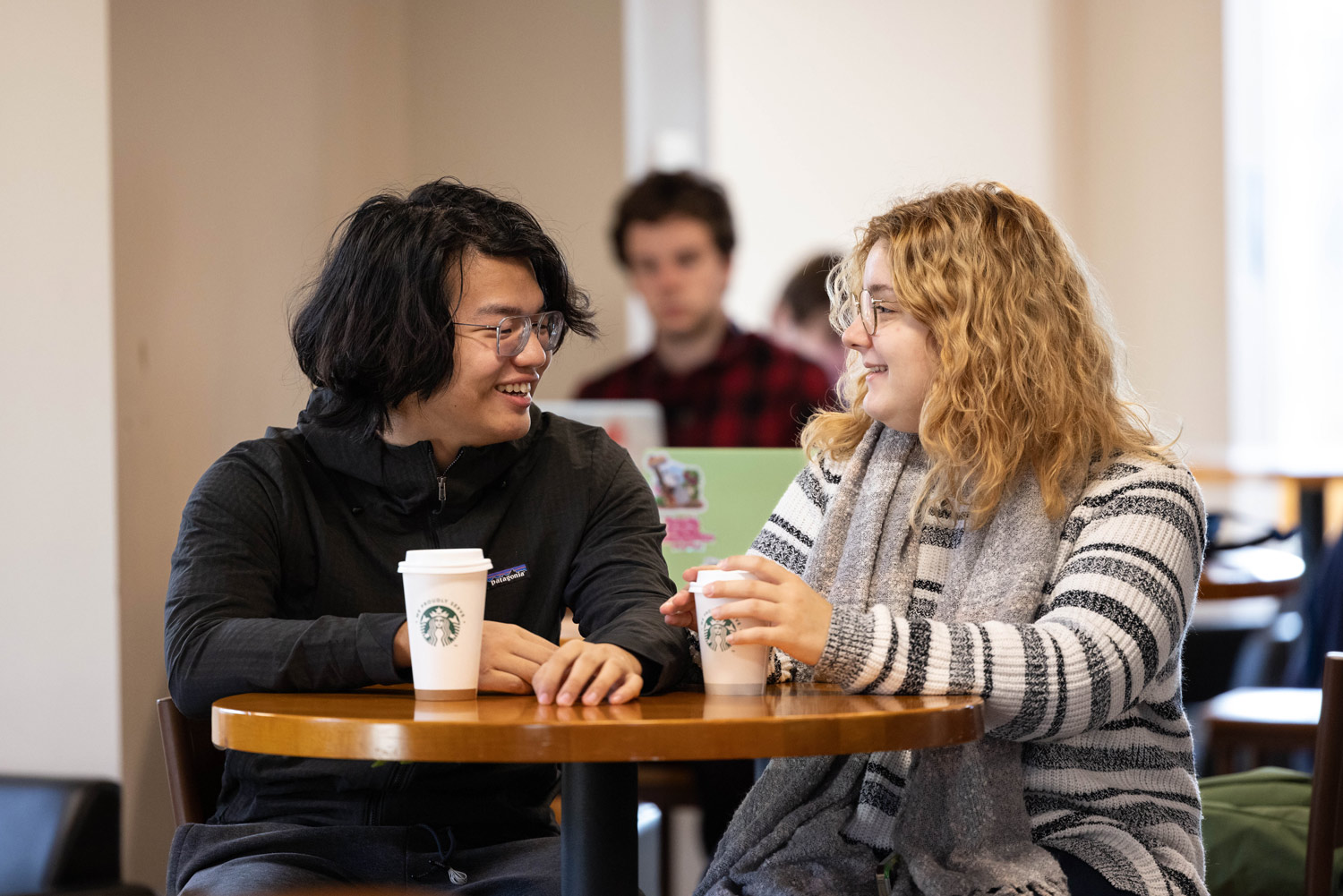 Two students having coffee together in the library
