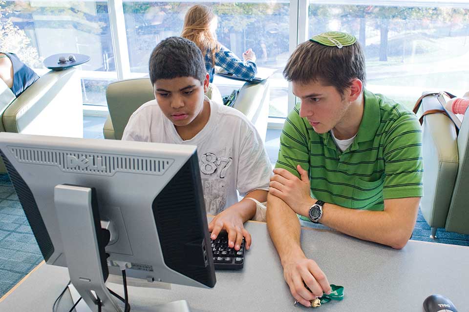 People in a library on a computer shown in color