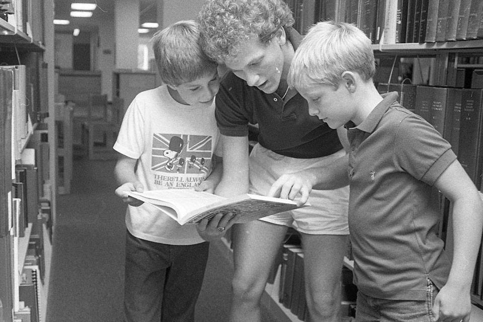 People in a library shown in a black and white photo