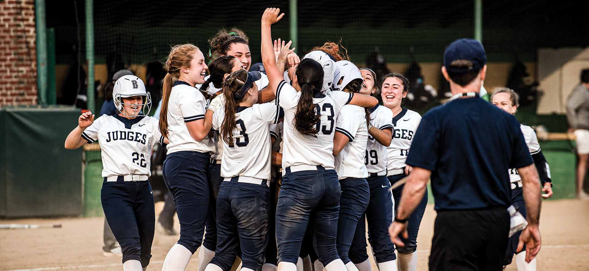 Softball players huddled in celebration