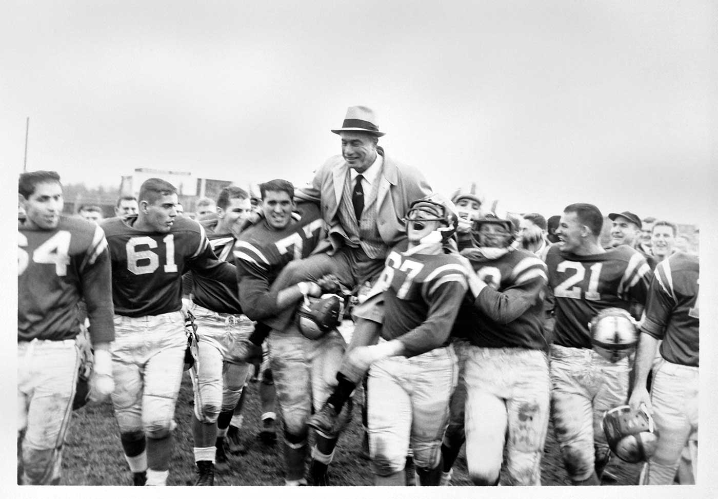 Football team holding up Benny Friedman