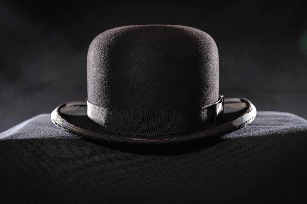 A shadowy photo of a derby hat.
