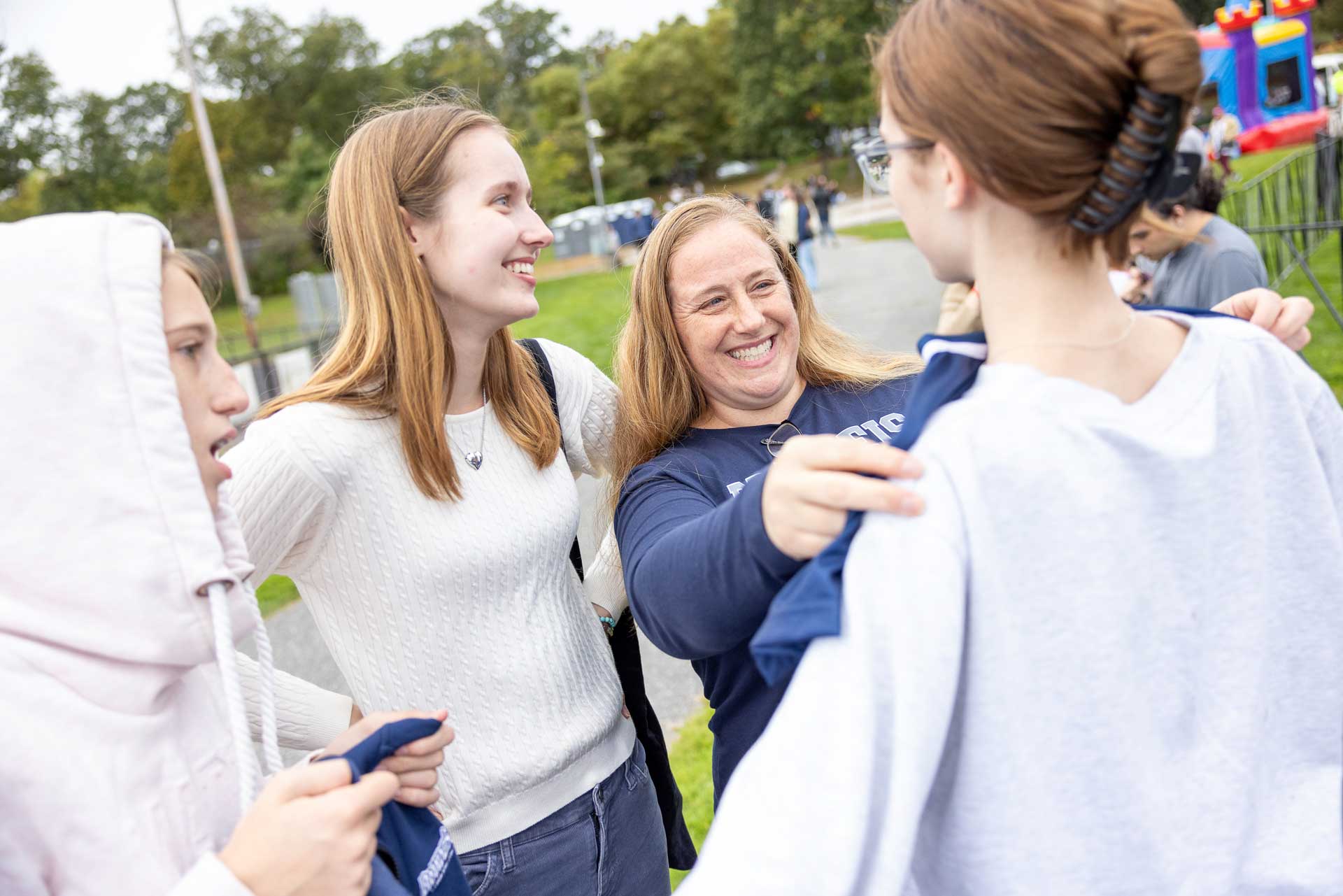 A parent, student, and family members laugh together.