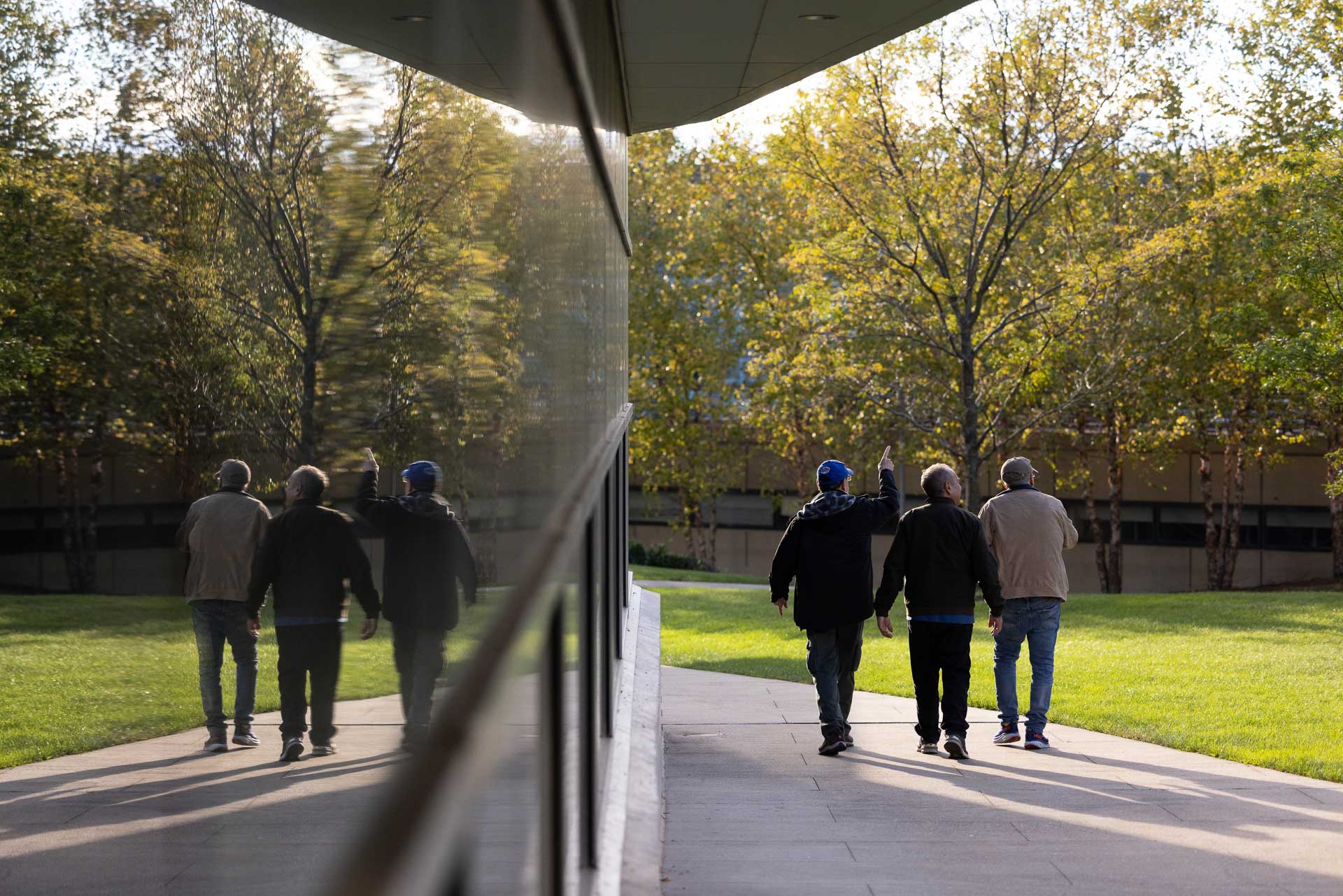 People walk away from camera beside a building